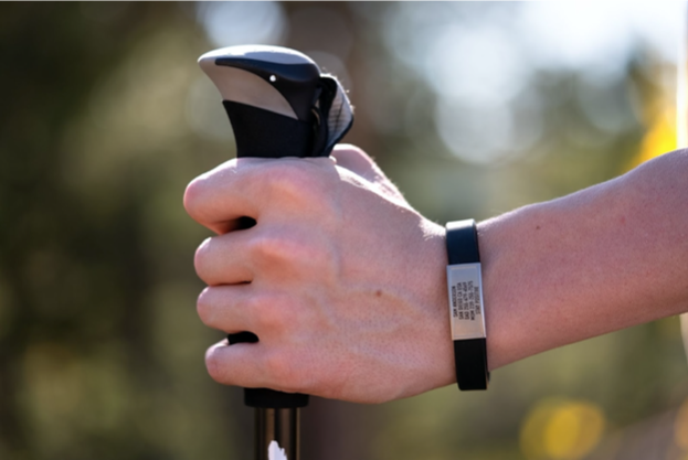 A person on a hiking trip wearing a medical ID in case of an emergency.