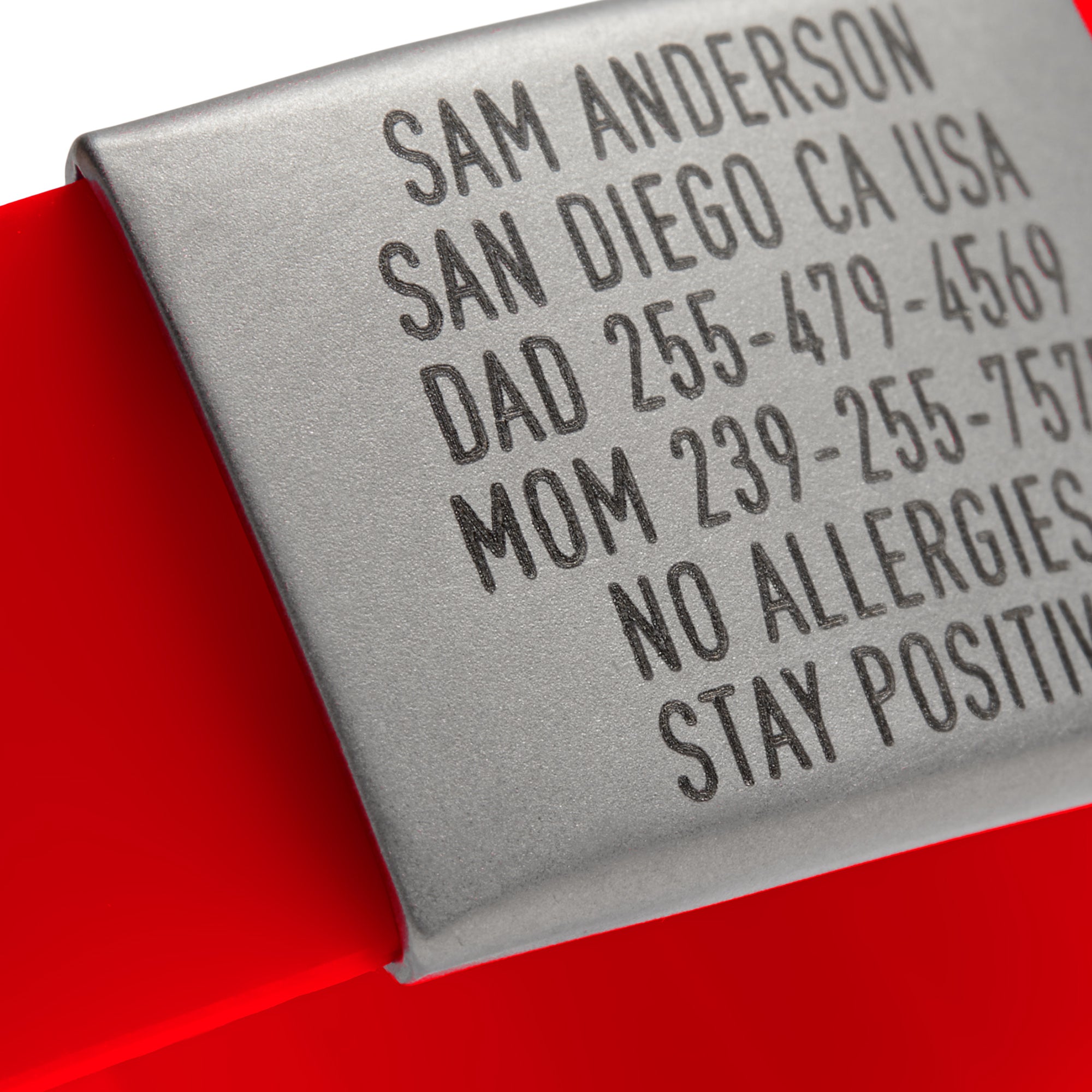Close-up of a Red silicone and silver ID tag with matching silver double locking clasp emergency wristband by BRECK iD.