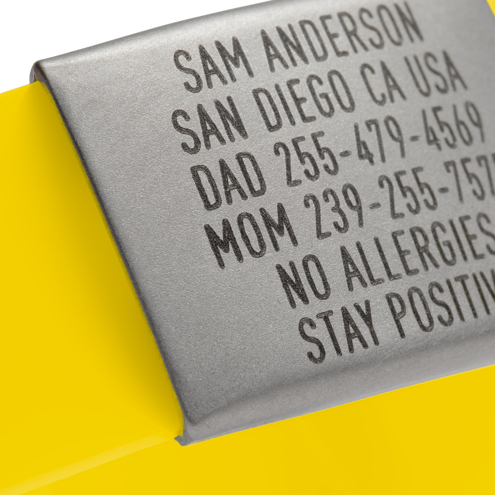 Close-up of a Yellow silicone and silver ID tag with matching silver double locking clasp emergency wristband by BRECK iD