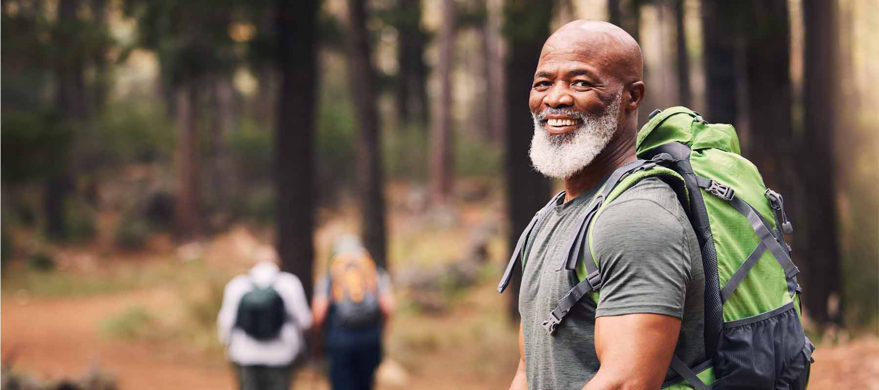 Man hiking by himself on path in woods.